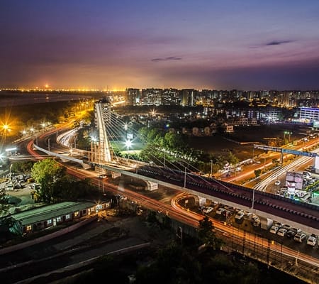 Surat: The Emerging IT Powerhouse of Gujarat Aerial night view of Surat city showcasing modern infrastructure, roads, and city lights symbolizing rapid urban and tech growth.